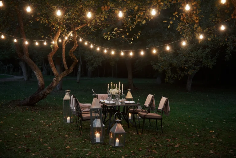 String lights glowing over a dinner table in an evening garden